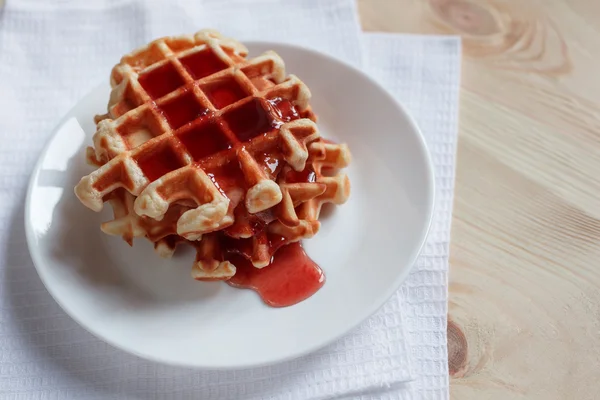 Gofres con miel, mermelada y bayas en un plato blanco, a primera vista — Foto de Stock