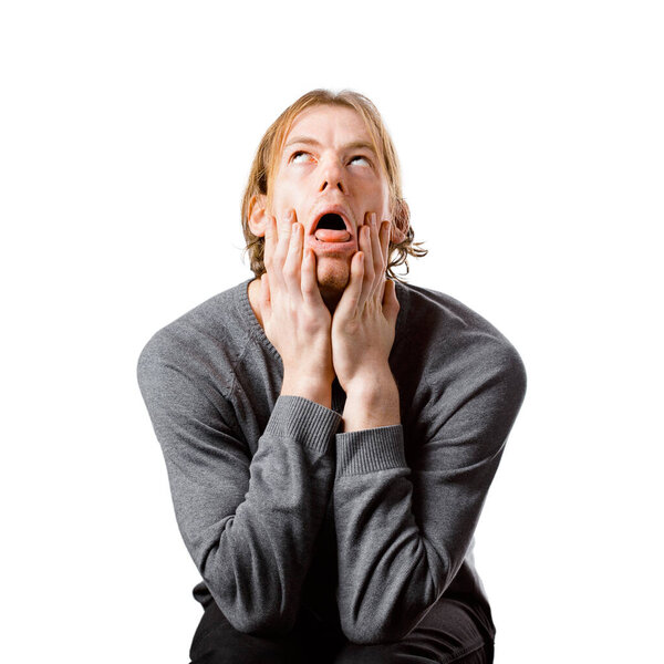 Мужской портрет светловолосого человека европейской внешности, на белом фоне. Эмоции. Ботаник-хипстер в очках сидит на стуле. Молодой обеспокоенный ботаник. Дурацкое лицо. Ботаник.