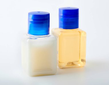 Beyaz arka planda şampuan ve duş jeli. Otelin kozmetik şişeleri beyaza izole edilmiş. Mini şişe takımı.