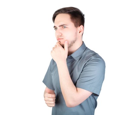 Beyaz arka planda düşünceli görünüşlü bir adam. Beyaz arka planda duran yakışıklı bir adam. Genç adam arka planda izole edildi. Genç bir adamın portresi. Beyaz arka planda bir adam