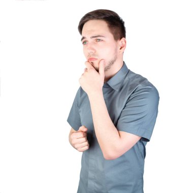 Beyaz arka planda düşünceli görünüşlü bir adam. Beyaz arka planda duran yakışıklı bir adam. Genç adam arka planda izole edildi. Genç bir adamın portresi. Beyaz arka planda bir adam