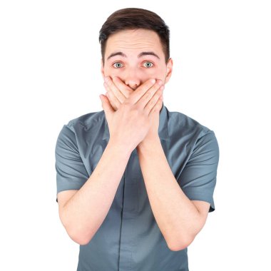 Sıradan bir yakışıklılık. Beyaz arka planda duran kendine güvenen genç, yakışıklı bir adam. Mutlu Genç Adam tecrit edilmiş arka plan. Genç bir adamın portresi. Sessiz bir jest yapan genç bir adam, izole edilmiş.