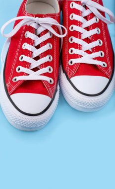 Mavi arka planda kırmızı spor ayakkabılar ve fotokopi alanı. Gençlik ayakkabıları.