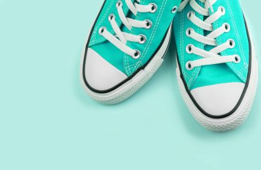 Mavi arka planda fotokopi alanı olan mavi spor ayakkabılar. Gençlik ayakkabıları.