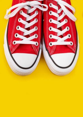 Sarı arka planda kırmızı spor ayakkabılar ve fotokopi alanı. Gençlik ayakkabıları.