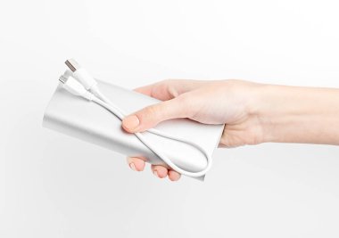 Gümüş güç bankası devrede. Mobil cihazları şarj etmek için güç bankası. Elektrik bankası olan akıllı bir telefon şarjı. Batarya. Mobil aygıtlar için dış pil.