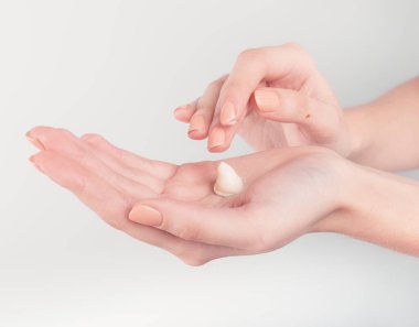 Spa tedavisi. El kremi sürerken kadın ellerini kapat. Kadın elinde krem tüpü tutuyor ve güzel ellerine nemlendirici krem sürüyor. Temiz ve yumuşak cilt için..