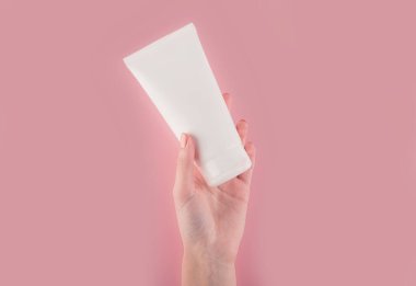 Spa tedavisi. El kremi sürerken kadın ellerini kapat. Kadın elinde krem tüpü tutuyor ve güzel ellerine nemlendirici krem sürüyor. Temiz ve yumuşak cilt için..