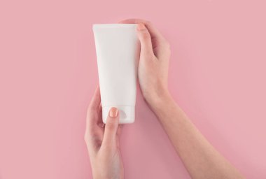 Spa tedavisi. El kremi sürerken kadın ellerini kapat. Kadın elinde krem tüpü tutuyor ve güzel ellerine nemlendirici krem sürüyor. Temiz ve yumuşak cilt için..