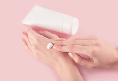 Spa tedavisi. El kremi sürerken kadın ellerini kapat. Kadın elinde krem tüpü tutuyor ve güzel ellerine nemlendirici krem sürüyor. Temiz ve yumuşak cilt için..