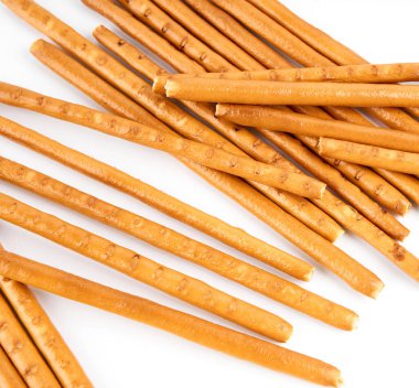                                Beyaz arka planda krakerlerden yapılmış yaratıcı bir düzen var. Yemek konsepti. Beyaz arka planda tuzlu, yenilebilir kuru çubuklar. Çubuklar, çubuklar krakerler.