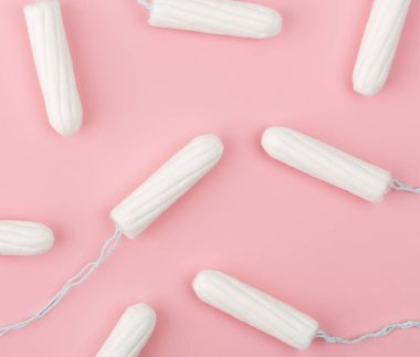 Pembe arka planda tıbbi kadın tamponu. Kadınlar için hijyenik beyaz tampon. Pamuklu çubuk. Regl, korunma aracı. Kırmızı arkaplanda tamponlar.