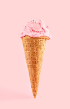 Pembe arka planda gözleme külahında pembe dondurma. Waffle külahında meyveli dondurma.