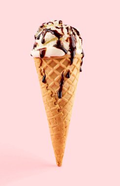 Pembe arka planda Waffle Cone 'da beyaz dondurma topu. Waffle külahında meyveli dondurma.