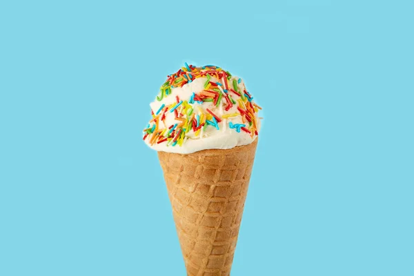 white ice cream ball in a Waffle Cone on a blue Background. Fruit ice cream in a waffle cone.