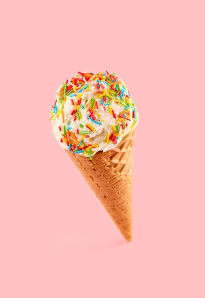 White ice cream ball in a Waffle Cone on a pink Background. Fruit ice cream in a waffle cone.