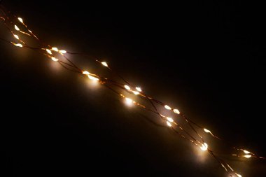 Işıklı ve bedava metin alanlı bir Noel arkaplanı. Noel ışıkları sınırda. Siyah arka planda parıldayan renkli Noel ışıkları. Yeni yıl. Noel zamanı. Dekorasyon. Çelenk.