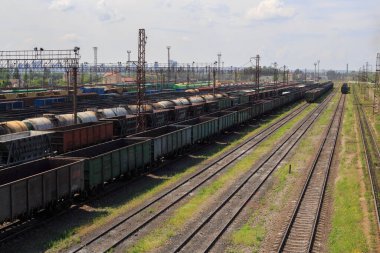 Şehir kargo terminalinde yük trenleri. Tren parkında demiryolları. Arain istasyona vardı. Işınlama lojistik arka planı için liman kullanımında yük treni konteynırına sahip kargo treni platformu.