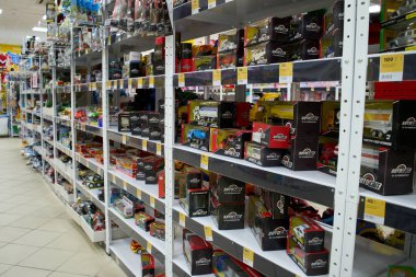 Bir sürü renkli oyuncağı olan raflar. Çocuk oyuncakçılarının geçmişi bulanık. Bir mağazadaki raflarda çeşitli inşaat oyuncakları var. Çocuk mağazasında oyuncak renkli plastik arabalar.