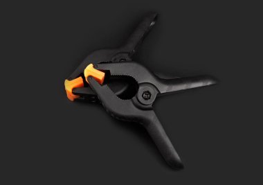 Bahar kıskacı siyah arkaplanda izole edildi. Siyah plastik klemp. Küçük ve büyük bir set. El işi, marangozluk, fotoğrafçılık, arabalar için klempleme ekipmanları. 