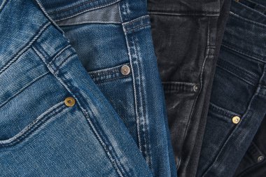 Beyaz arka planda kot pantolon desenli mavi kot pantolonların çeşitli tonlarında. Tasarım için Denim arkaplan dokusu. Kumaş kumaş. Arkaplan olarak kullanılabilen mavi kot.