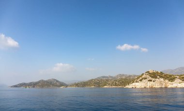 Akdeniz dağlara tepeden bakıyor. Deniz dalgalarının havadan görünüşü turkuaz deniz suyuyla sahildeki kayalara çarpıyor. Sahildeki inanılmaz kayalık deniz manzarası.