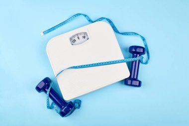 Banyo tartıları ve kilo verme konsepti için mezura. Kilo vermek için spor ve diyet. Banyo terazisi, mezura ve dambıl.. 