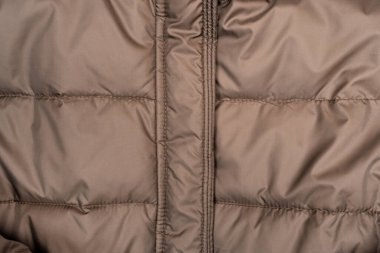 Yüksek yakalı ve fermuarlı kahverengi kabarık ceket, beyaz arka planda izole edilmiş. Kış modasına, giyim mağazasına, e-ticarete ve mevsimlik reklamlara hazır..