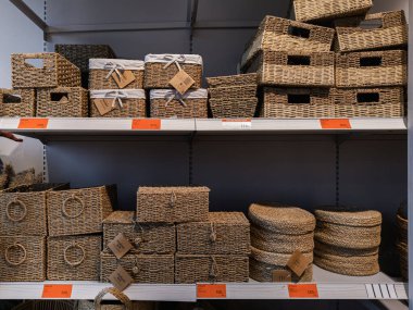 Dnipro, Ukrayna 10.13.2025: Saman veya hasır gibi doğal malzemelerden yapılan ve ev dekorasyonu için sergilenen çeşitli dokuma depolarla dolu raflar. Ev organizasyonu, iç tasarım