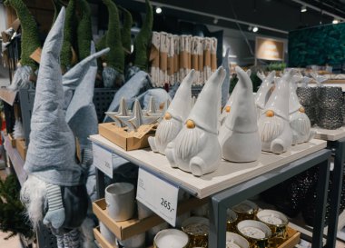 Dnipro, Ukrayna 10.12.2025: Uzun çizgili şapkalar ve cam adaklarla Noel cüce bebeklerinin (nisser, tomte) perakende sergilenmesi. Tatil dekorasyonu ve hediye fikirleri için uygun..