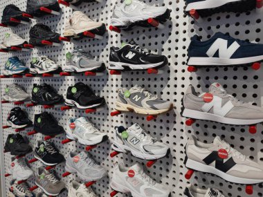 Dnipro, Ukrayna 10.12.2025: Multiple New Denance Running and Lifestyle Sneakers 'ın Duvar Gösterimi. Modern Perakende Dükkanı