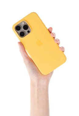 Dnipro, Ukrayna, 29 Nisan 2025: Yeni bir Apple iPhone 'u sarı bir çantada beyaz arka planda tutan bir elin stüdyo fotoğrafı.
