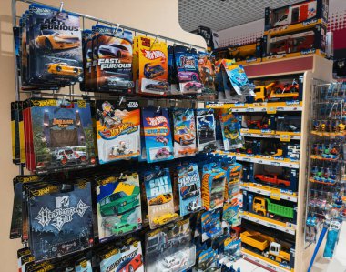 Dnipro, Ukrayna 11.13.2025: Hot Wheels marka die-cast arabalar, pist setleri ve perakende satış rafında sergilenen aksesuarlar. Simgesel minyatür araba markasını ve oyuncak seçimini yakalar.