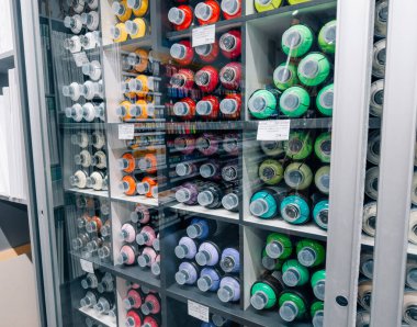 Dnipro, UKRAINE 09.06.2025: Grafiti, sokak sanatı, tasarım, DIY projeleri, yaratıcı işler ve sanatçılar için çok renkli aerosol boyaları satan sanat malzemeleri mağazasındaki raflarda bulunan renkli sprey boya kutuları