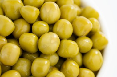 Taze bezelye arkaplanı, arka plan olarak mükemmel soyulmuş bezelye tanelerinin dokusu. Sebze, sebze proteini, sağlıklı ürünler. Bezelye konservesi. bir çember içinde dönüyor