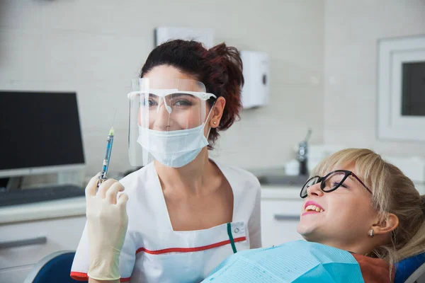 Koruma maskeli kadın dişçi elinde anesteziyle şırınga tutuyor. — Stok fotoğraf