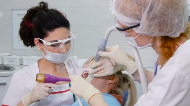 Professional stomatologist and dental assistant working with patient. — Stock Video