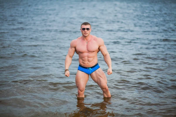 Stark sportig muskulös man står i floden. — Stockfoto