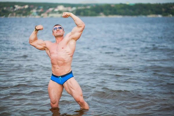 Forte desportivo muscular homem de pé no rio. — Fotografia de Stock