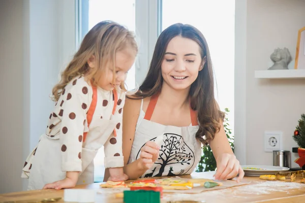 Moeder en peuter dochter bakken peperkoek koekjes voor Kerstmis. Rechtenvrije Stockfoto's