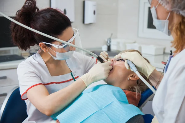 Zbliżenie ujęcia dentysty w masce ochronnej pracującego z ubytkiem zęba. — Zdjęcie stockowe