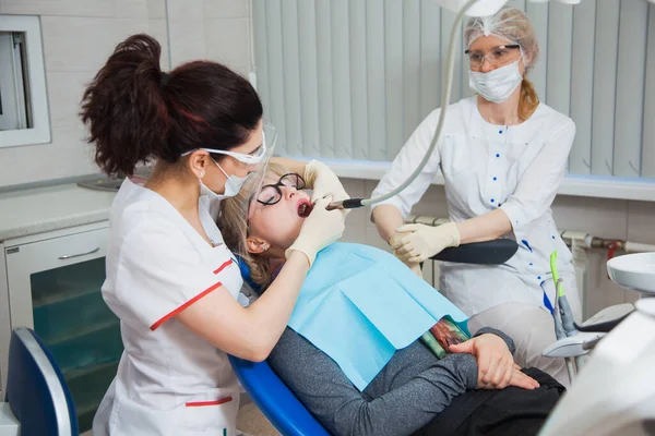 Zbliżenie ujęcia dentysty w masce ochronnej pracującego z ubytkiem zęba. — Zdjęcie stockowe