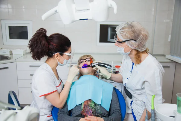 Zbliżenie zdjęcia dentysty i asystenta w masce ochronnej pracujących z ubytkiem zęba. — Zdjęcie stockowe