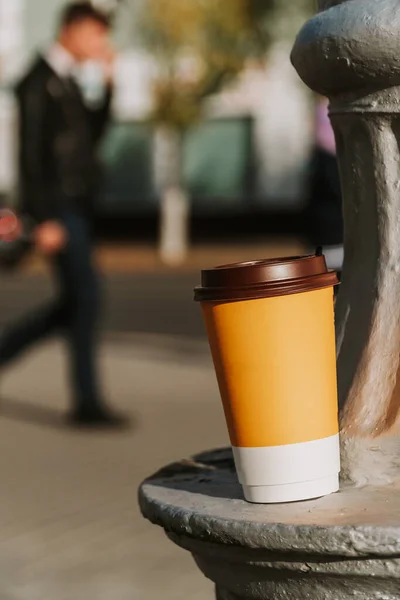 Paper cup with coffee on the background of the city