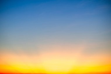 Sunset or sunrise sky with a vibrant gradient of orange, gold, and soft blue. Clear atmosphere with wispy clouds. Peaceful, natural light background. hope, freedom, new day and inspirational Concepts