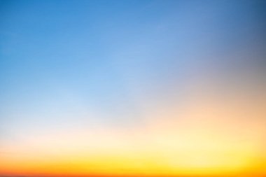 Sunset or sunrise sky with a vibrant gradient of orange, gold, and soft blue. Clear atmosphere with wispy clouds. Peaceful, natural light background. hope, freedom, new day and inspirational Concepts