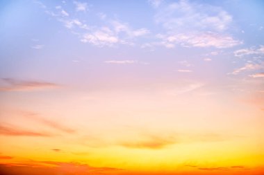 Sunset or sunrise sky with a vibrant gradient of orange, gold, and soft blue. Clear atmosphere with wispy clouds. Peaceful, natural light background. hope, freedom, new day and inspirational Concepts