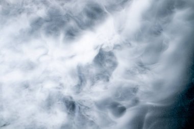 Mavi arka planda dönen beyaz buhar ya da duman yumuşak ve rüya gibi soyut bir doku yaratıyor. Özgeçmiş, tasarım konseptleri, spa, rahatlama ve doğal atmosfer temaları için mükemmel..