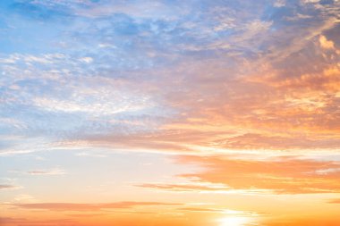 Sunset or sunrise sky with a vibrant gradient of orange, gold, and soft blue. Clear atmosphere with wispy clouds. Peaceful, natural light background. hope, freedom, new day and inspirational Concepts