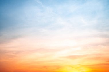 Sunset or sunrise sky with a vibrant gradient of orange, gold, and soft blue. Clear atmosphere with wispy clouds. Peaceful, natural light background. hope, freedom, new day and inspirational Concepts